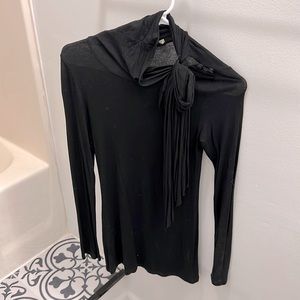 Black long sleeve blouse with accent buttons at collarbone, tie at neckline.